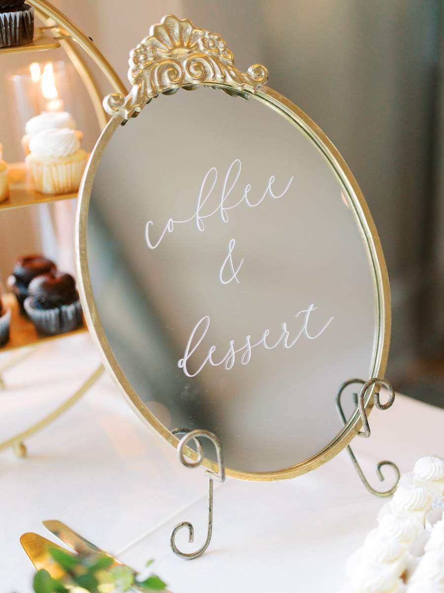 Small ornate gold mirror on easel as dessert sign