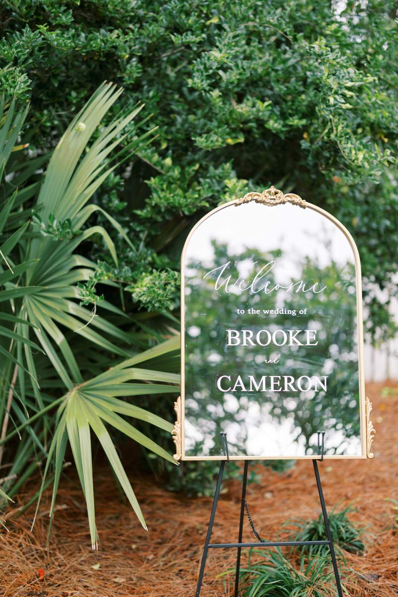 Large gold mirror as welcome sign on black iron easel